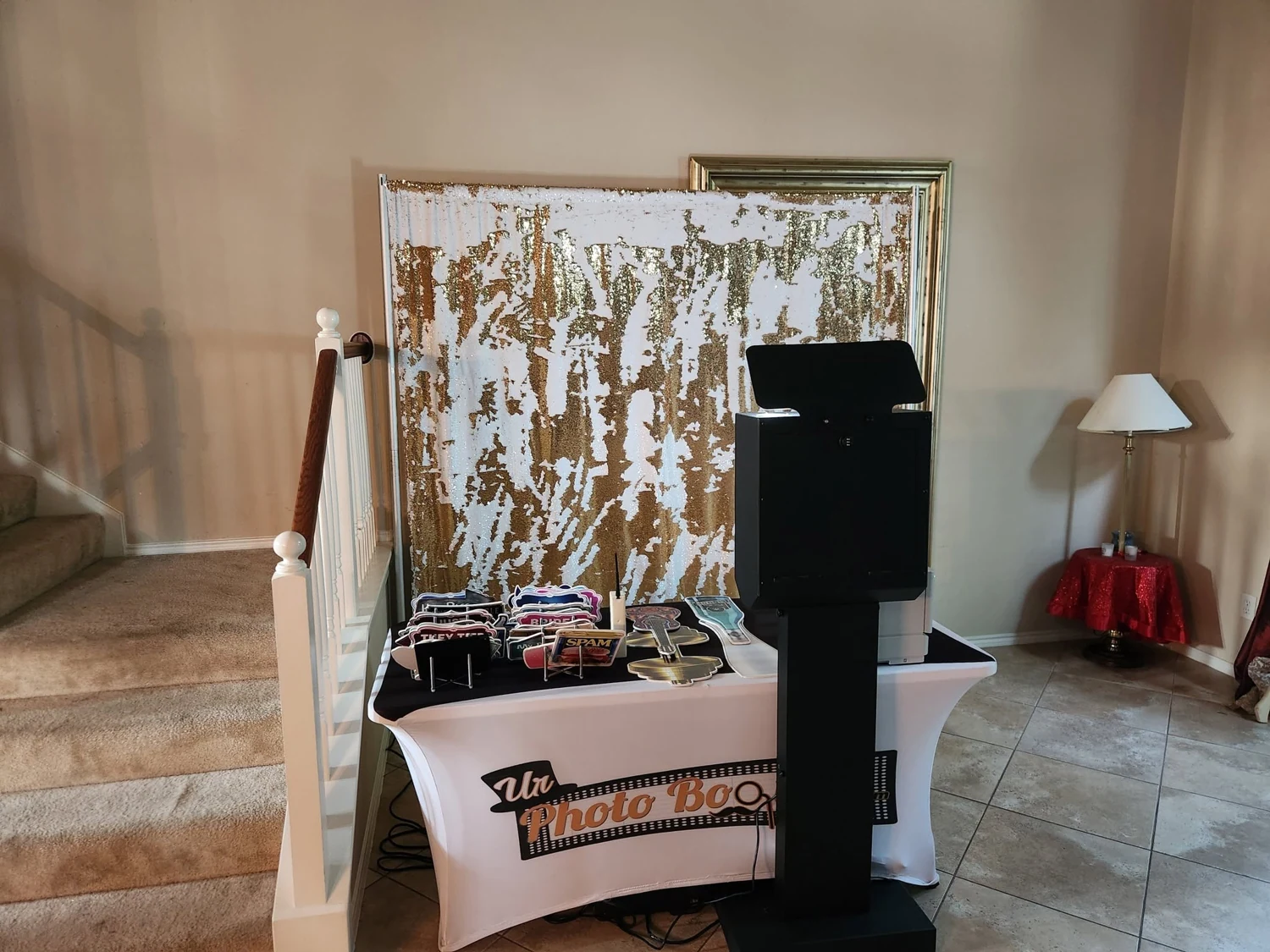 Our photo booth setup: Gold-and-white backdrop, photo booth and props